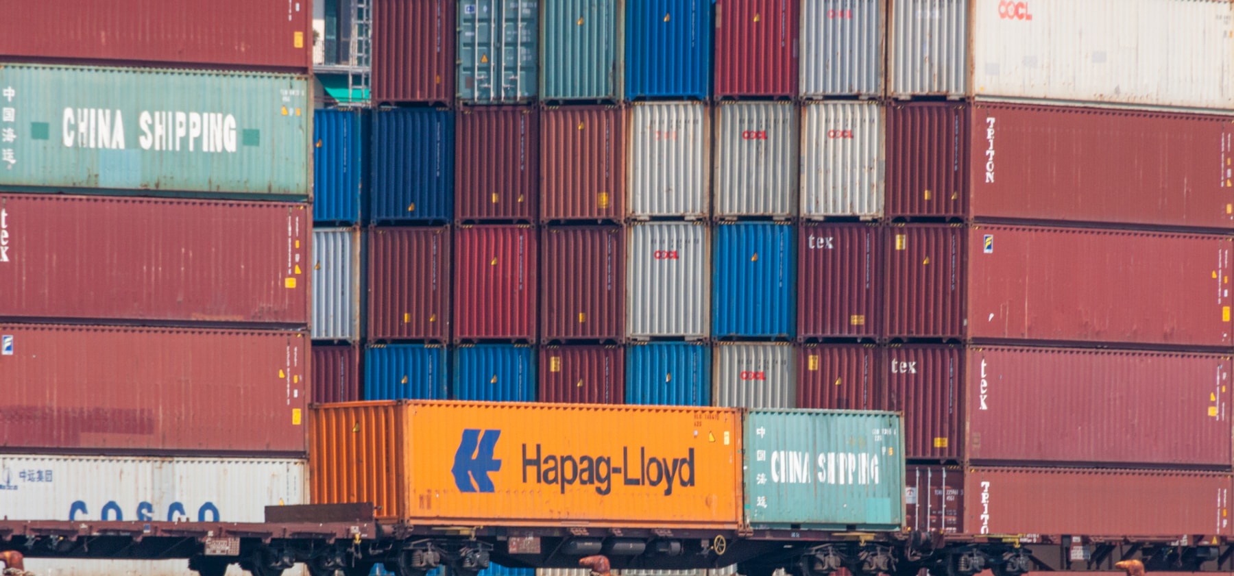 Truck positioned beside stacked intermodal containers